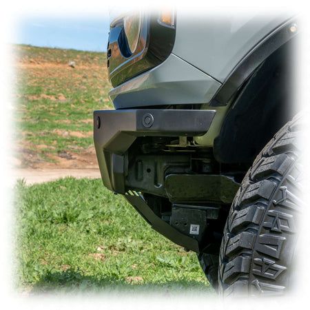 Turn Offroad Hyperlyte front bumper installed on olive green Ford Bronco, close-up showing bumper corner and wheel in grass field