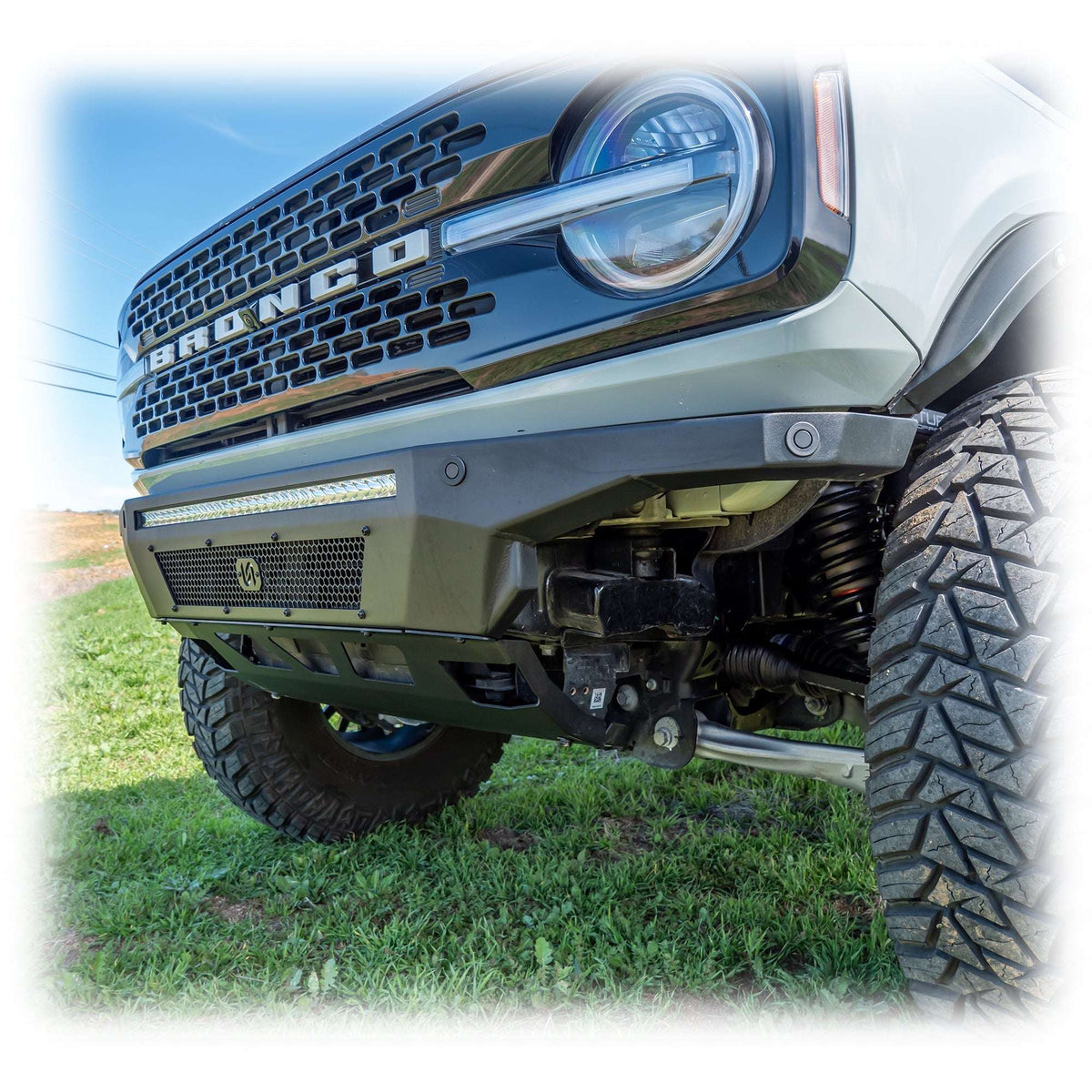 Turn Offroad Hyperlyte front bumper installed on olive green Ford Bronco, front three-quarter close-up view on hillside