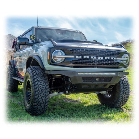 Turn Offroad Hyperlyte front bumper installed on olive green Ford Bronco, distant front three-quarter view of full vehicle on mountain terrain