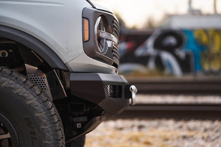 DV8 Offroad OE Plus Series front bumper installed on silver Ford Bronco, side profile close-up showing fender and bumper corner