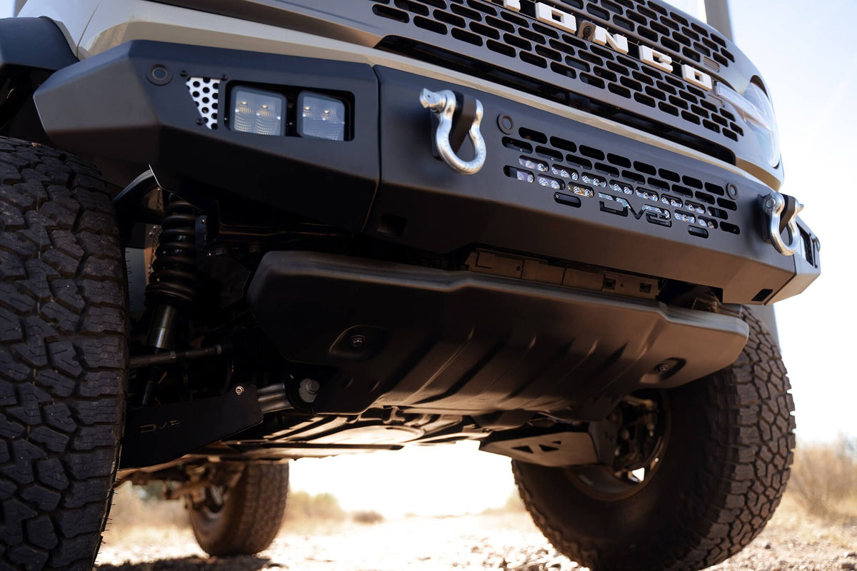 DV8 Offroad OE Plus Series front bumper installed on Ford Bronco, underside close-up on desert terrain