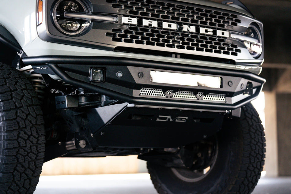 DV8 Offroad Competition Series front bumper installed on dark Ford Bronco, close-up showing bumper corner and wheel in parking garage