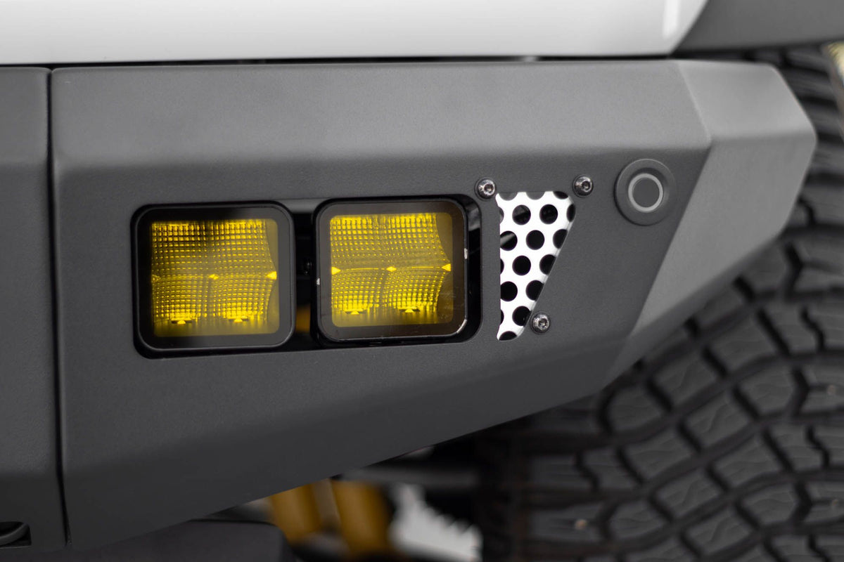 DV8 Offroad OE Plus Series V2 front bumper installed on gray Ford Bronco, close-up showing bumper corner and amber light pod
