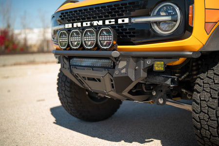 DV8 Offroad Tube Series front bumper installed on black Ford Bronco, close-up showing round lights and wheel