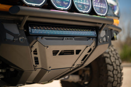DV8 Offroad Tube Series front bumper installed on orange Ford Bronco, close-up showing light bar at dusk