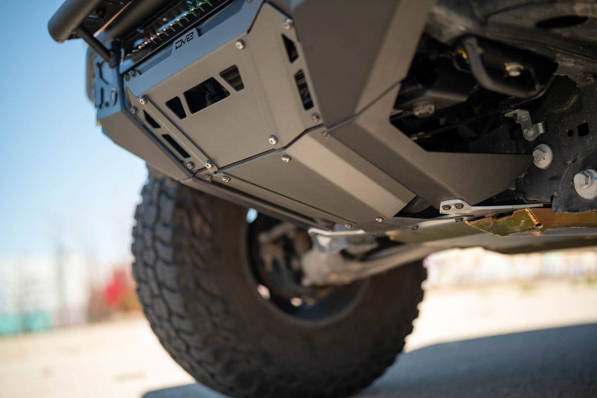 DV8 Offroad Tube Series front bumper installed on Ford Bronco, underside close-up showing skid plate