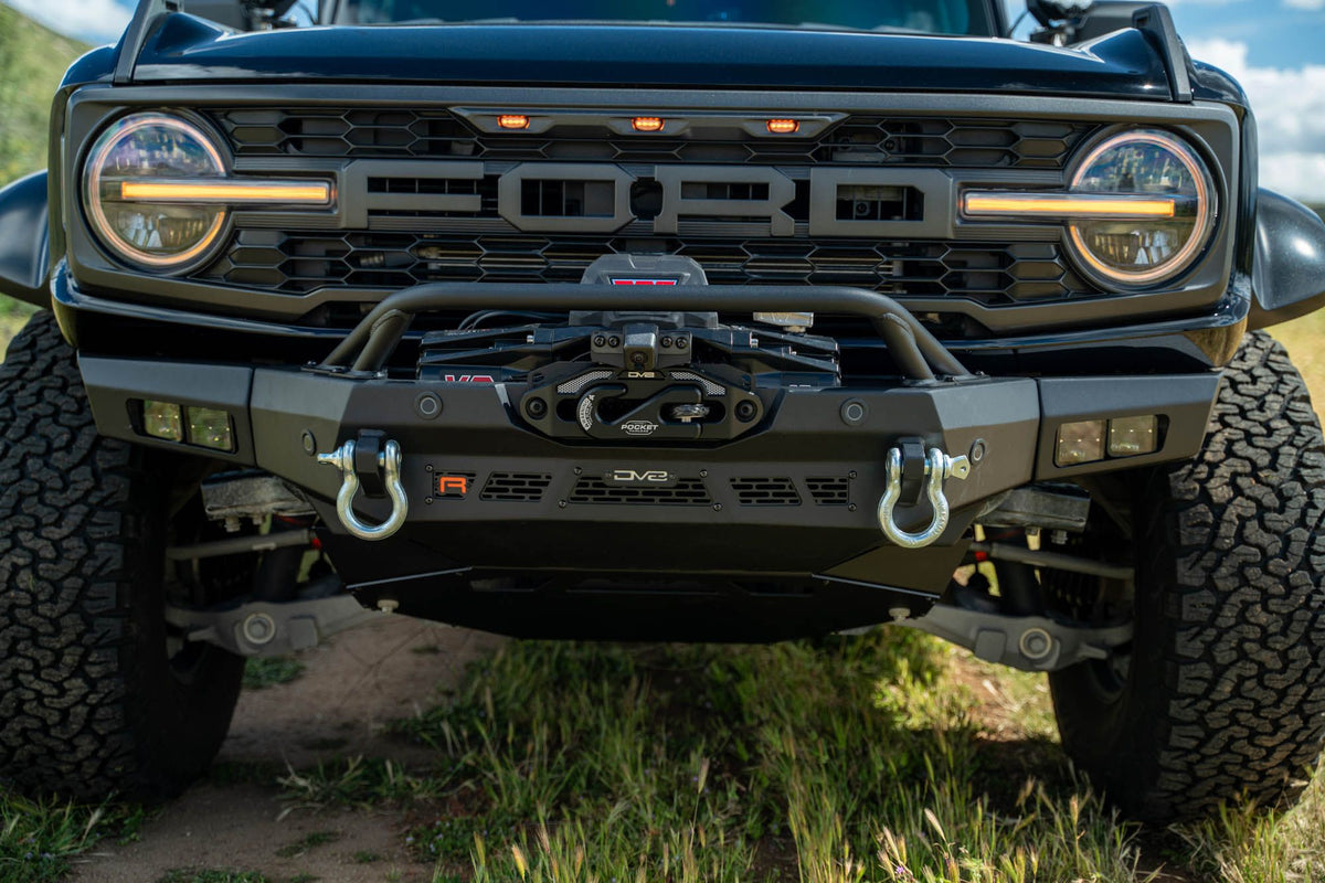 DV8 Offroad Spec Series winch front bumper installed on black Ford Bronco Raptor, straight-on close-up showing grille and headlights