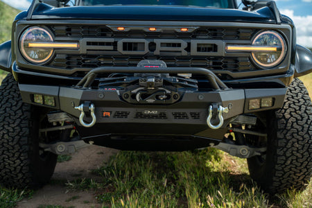 DV8 Offroad Spec Series winch front bumper installed on black Ford Bronco Raptor, straight-on close-up showing grille and headlights