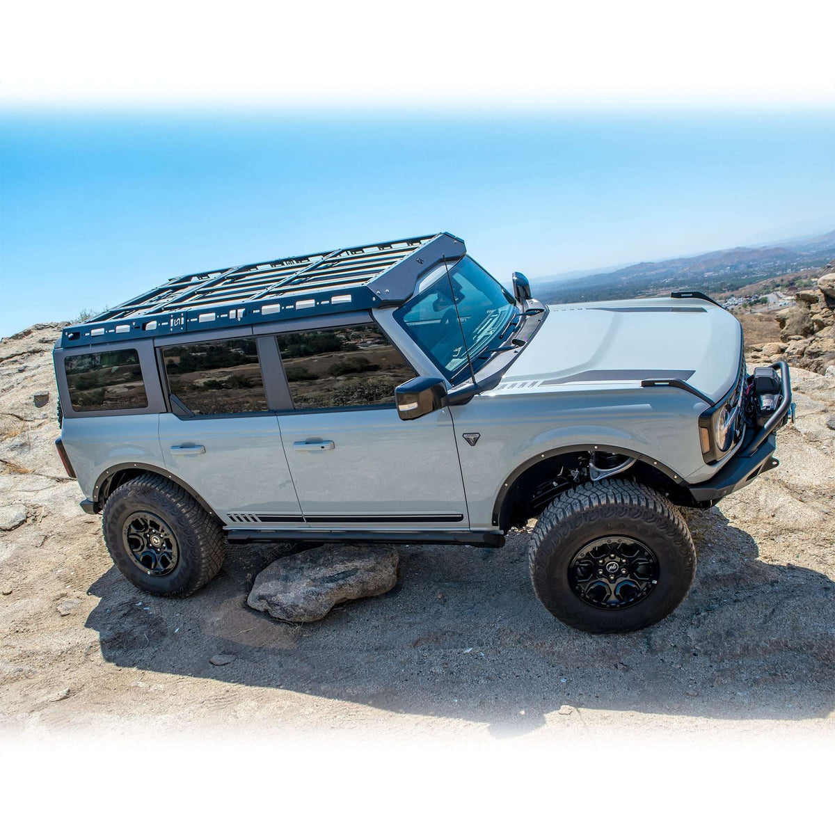 Turn Offroad fender delete kit installed on 4-door Ford Bronco with roof rack, side profile view on rocky trail