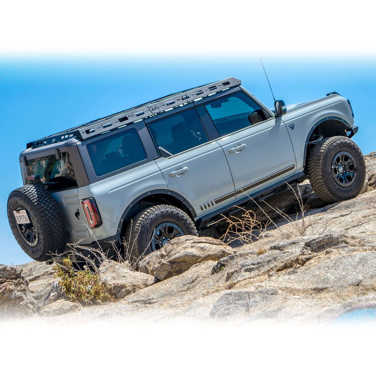 Turn Offroad fender delete kit installed on Ford Bronco, front three-quarter view on rocky overlook with coastal background