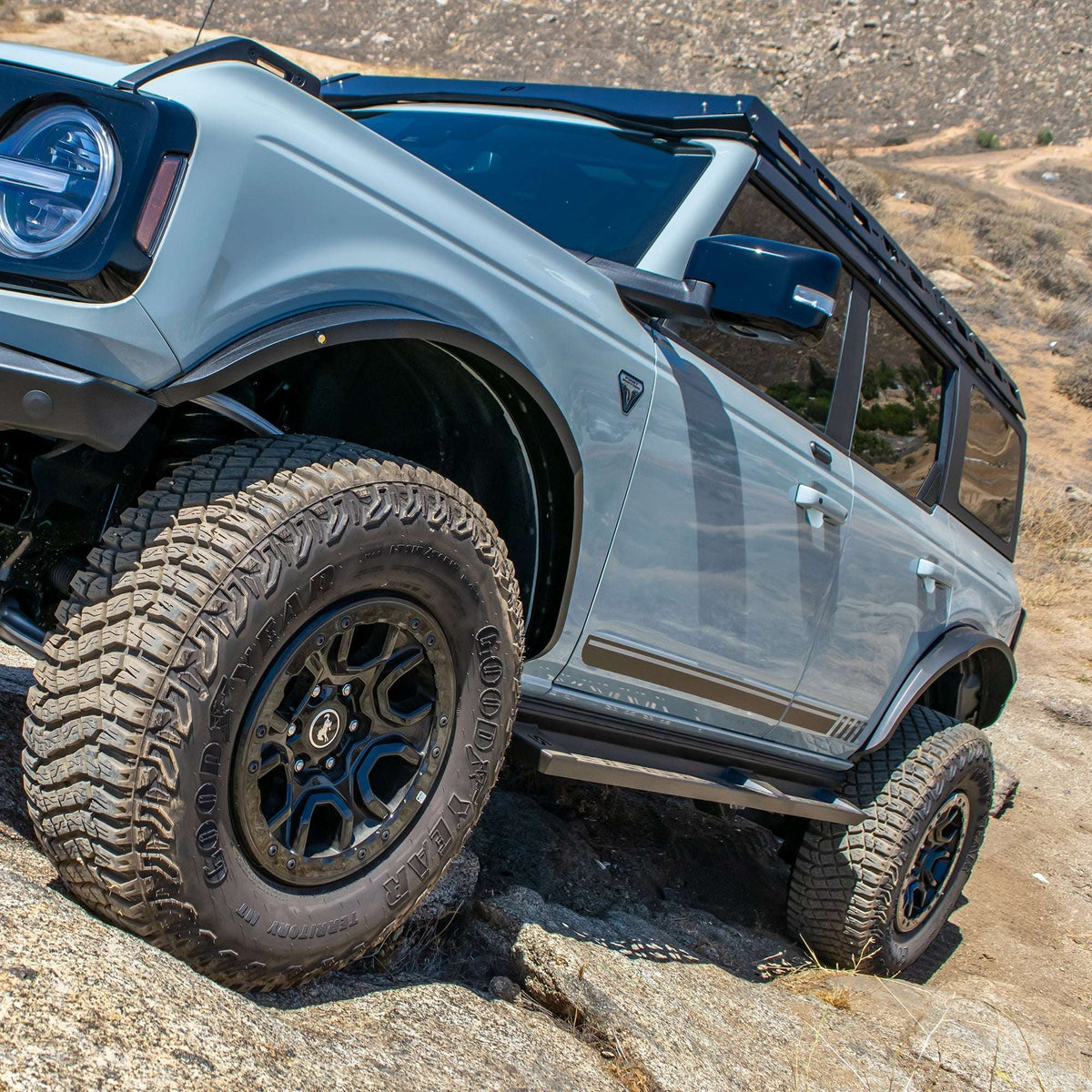 Turn Offroad steel fender flares installed on Ford Bronco, front three-quarter close-up with roll bar on rocky terrain