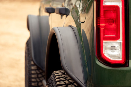 DV8 Offroad tube fender flares installed on green 4-door Ford Bronco, close-up rear fender and taillight