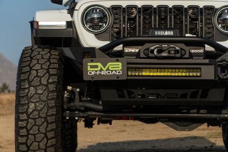 DV8 Offroad universal D-ring license plate mount installed on Jeep front view showing bracket on aftermarket bumper