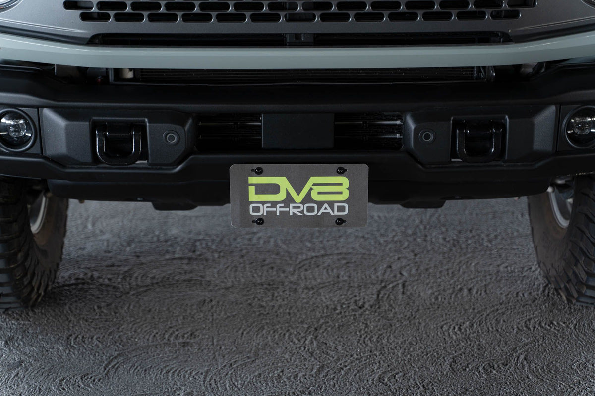 DV8 Offroad license plate mount installed on 2021-2026 Ford Bronco full front view showing complete bumper setup