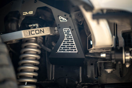 DV8 Offroad front inner fenders installed on Ford Bronco, close-up showing coilover suspension and Icon badge on mesh panel