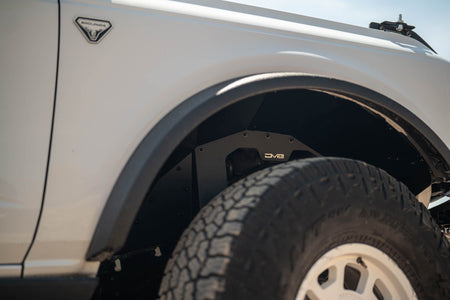 DV8 Offroad front inner fenders installed on white Ford Bronco, close-up showing fender and tire with DV8 logo