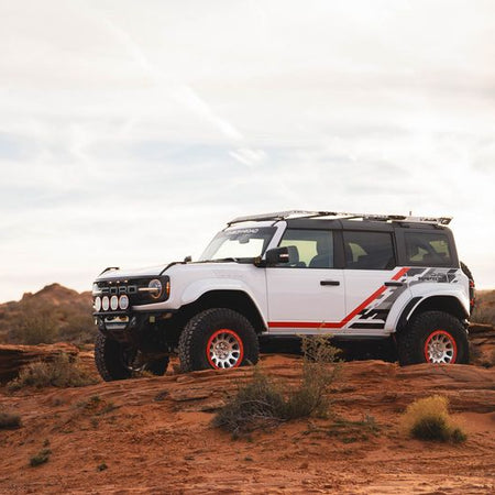 DV8 Offroad Tube Series front bumper installed on white Ford Bronco Raptor 2-door – front three-quarter desert shot
