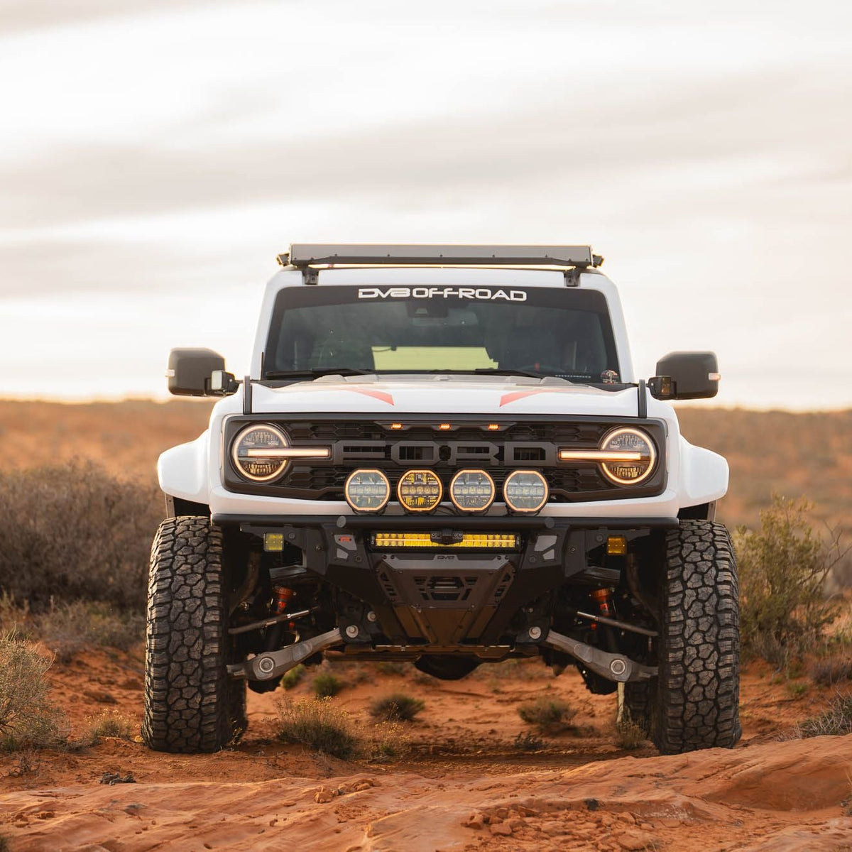 DV8 Offroad Tube Series front bumper installed on white Ford Bronco Raptor – full front three-quarter view desert terrain
