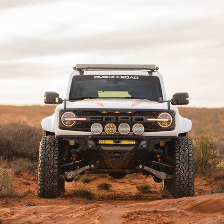 DV8 Offroad Tube Series front bumper installed on white Ford Bronco Raptor – full front three-quarter view desert terrain
