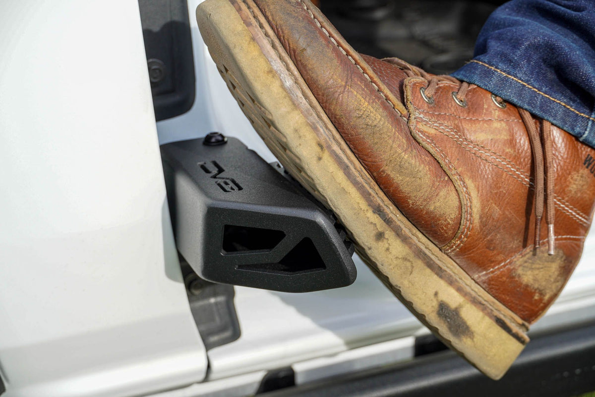 DV8 Offroad foot peg in use on 2021-2026 Ford Bronco showing foot on anti-slip peg step surface