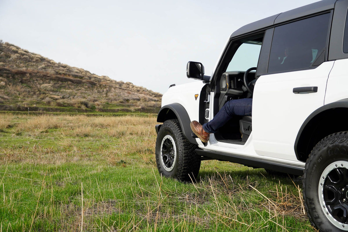DV8 Offroad foot pegs installed on 2021-2026 Ford Bronco doorless configuration wide landscape shot