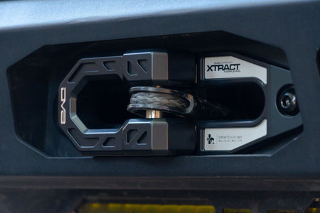 DV8 Offroad Xtract fairlead installed on dark gray bumper, close-up product detail shot