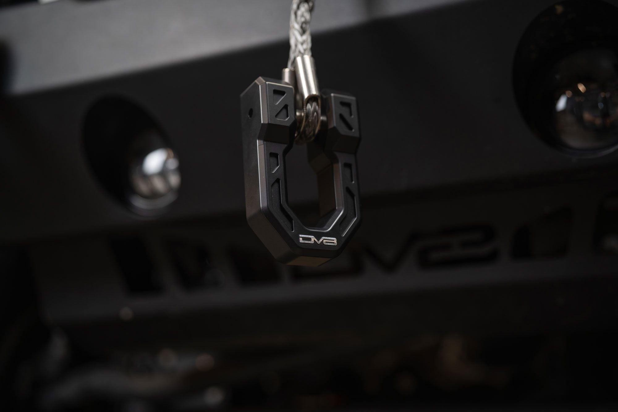 DV8 Offroad Xtract fairlead installed on bumper, low-light close-up with keys hanging from nearby hook